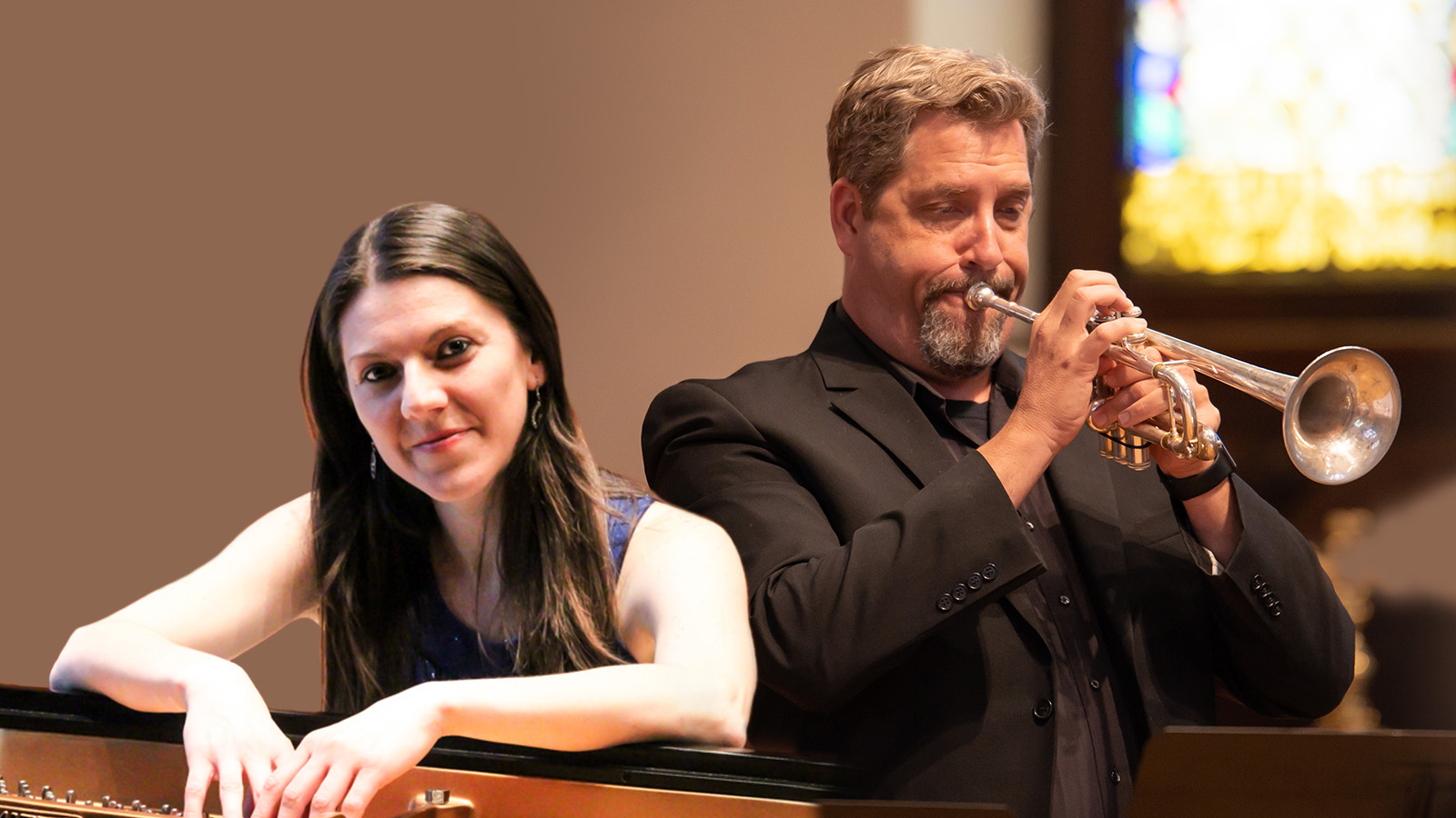 woman standing and man playing trumpet